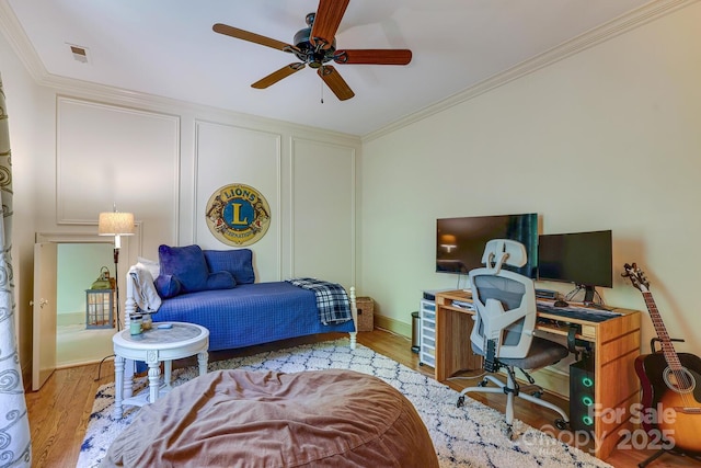 bedroom featuring crown molding, wood finished floors, and visible vents