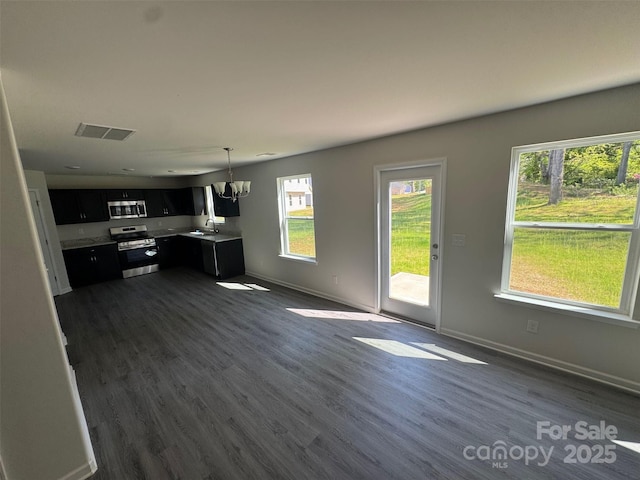 436 Phifer Rd, Kings Mountain, NC 28086 - kitchen with appliances with stainless steel finishes, dark cabinets, dark wood-style flooring, and a chandelier