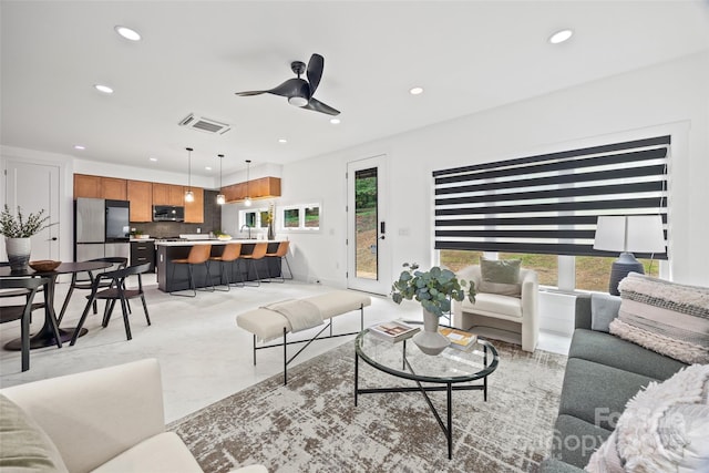 living area with visible vents, ceiling fan, and recessed lighting