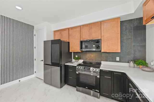 kitchen featuring light countertops, marble finish floor, recessed lighting, appliances with stainless steel finishes, and backsplash