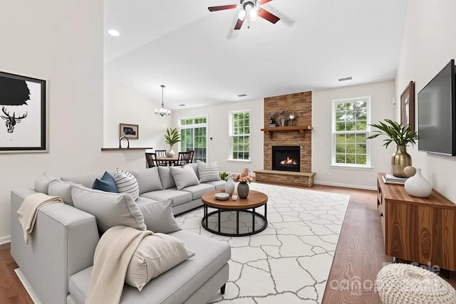 9506 Minnie Lemmond Ln Unit 170, Mint Hill, NC 28227 - living area with wood finished floors, a ceiling fan, vaulted ceiling, a chandelier, and a stone fireplace