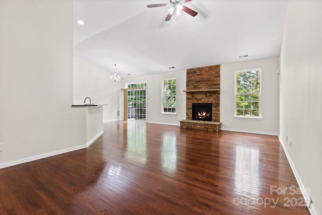 9506 Minnie Lemmond Ln Unit 170, Mint Hill, NC 28227 - unfurnished living room featuring a ceiling fan, wood finished floors, a chandelier, lofted ceiling, and a stone fireplace