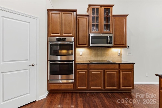 9506 Minnie Lemmond Ln Unit 170, Mint Hill, NC 28227 - kitchen featuring stainless steel appliances, dark wood-style flooring, decorative backsplash, glass insert cabinets, and baseboards
