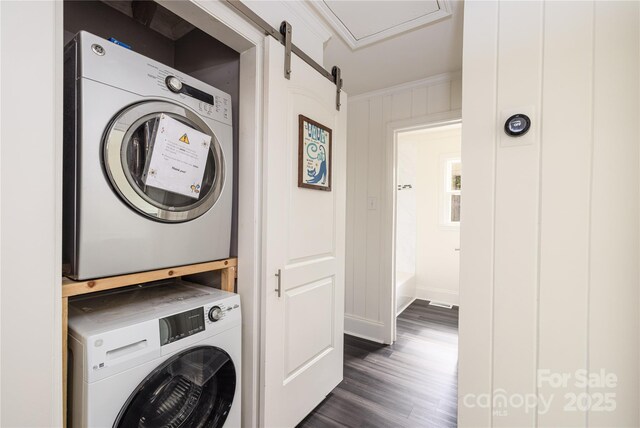 2741 Cowles Rd, Charlotte, NC 28208 - laundry area featuring stacked washer and clothes dryer, crown molding, dark wood-style flooring, a barn door, and laundry area