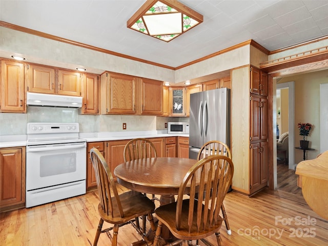 195 Nature Ln, Waynesville, NC 28786 - kitchen featuring light countertops, light wood-type flooring, under cabinet range hood, white appliances, and ornamental molding