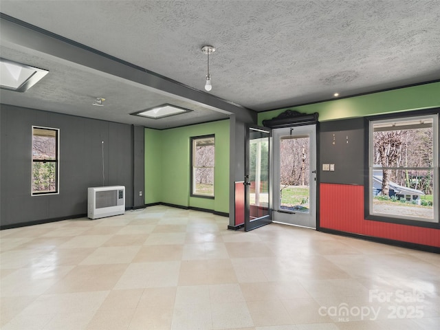195 Nature Ln, Waynesville, NC 28786 - unfurnished room with tile patterned floors, a skylight, baseboards, and a textured ceiling