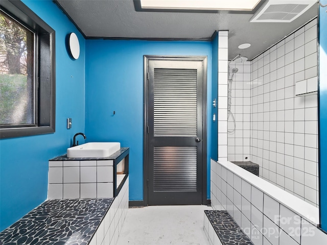 195 Nature Ln, Waynesville, NC 28786 - full bathroom with a sink, a textured ceiling, tiled shower, and visible vents