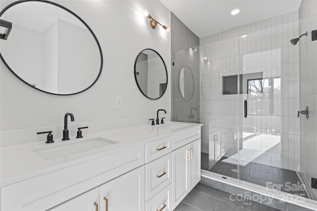 full bathroom featuring double vanity, a sink, a shower stall, and tile patterned floors