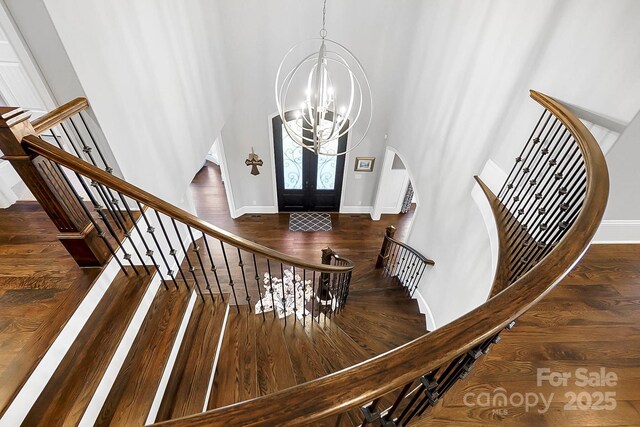 1311 Sunnys Halo Ln, Waxhaw, NC 28173 - foyer entrance with arched walkways, a chandelier, wood finished floors, stairs, and a high ceiling