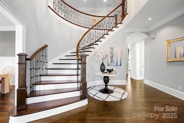 1311 Sunnys Halo Ln, Waxhaw, NC 28173 - staircase featuring a high ceiling, ornamental molding, arched walkways, and wood finished floors