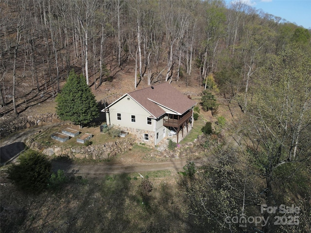 aerial view of property's location featuring a forest