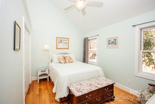 bedroom featuring light wood-type flooring, baseboards, vaulted ceiling, and a ceiling fan