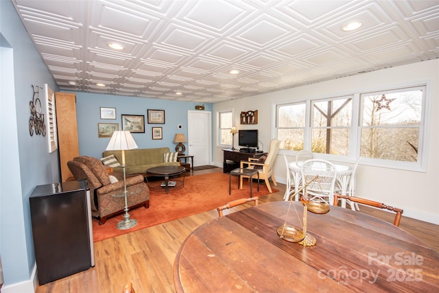 living area featuring an ornate ceiling, light wood-style floors, recessed lighting, and baseboards