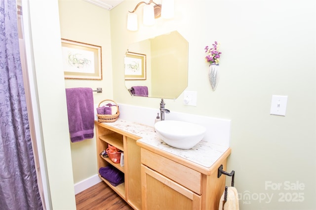 bathroom featuring vanity, wood finished floors, and baseboards