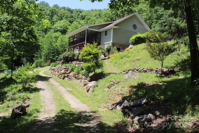 view of yard with a forest view and driveway