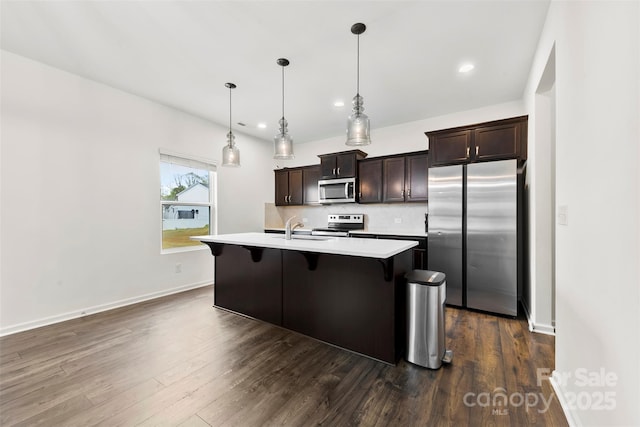 kitchen featuring light countertops, a sink, dark brown cabinets, and stainless steel appliances