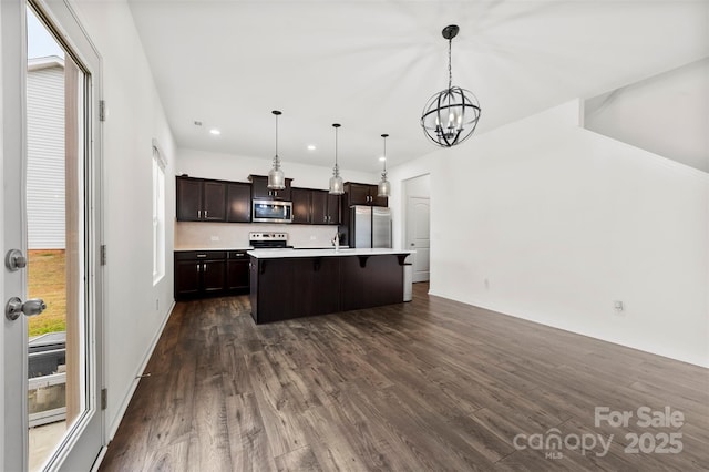 kitchen featuring dark wood-style flooring, dark brown cabinets, appliances with stainless steel finishes, an inviting chandelier, and light countertops