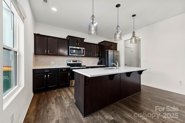 1976 Ethan Ln, Stanfield, NC 28163 - kitchen featuring appliances with stainless steel finishes, an island with sink, a sink, a kitchen bar, and backsplash