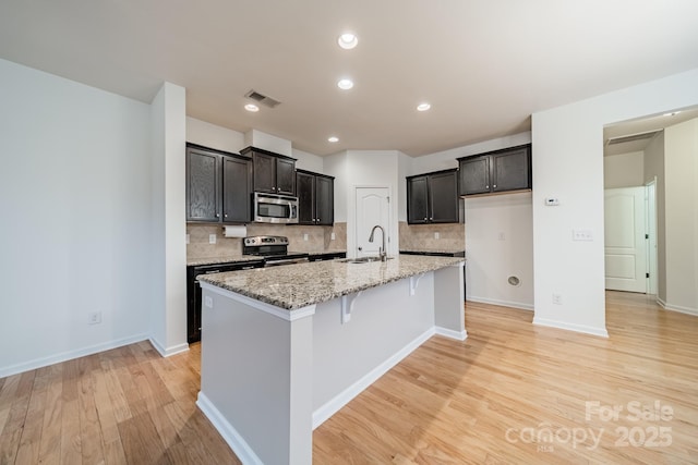 9001 Lanark Ln, Indian Land, SC 29707 - kitchen featuring electric range oven, stainless steel microwave, decorative backsplash, light wood finished floors, and recessed lighting