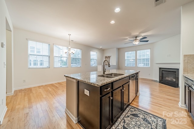 9001 Lanark Ln, Indian Land, SC 29707 - kitchen with a sink, a fireplace with flush hearth, light wood finished floors, open floor plan, and dark brown cabinetry