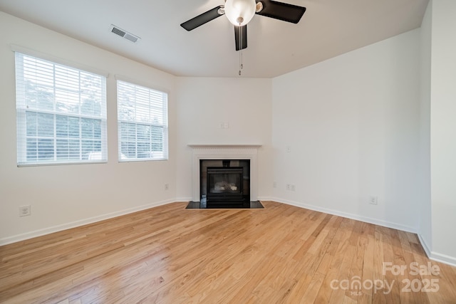 9001 Lanark Ln, Indian Land, SC 29707 - unfurnished living room featuring light wood-style floors, a fireplace with flush hearth, a ceiling fan, and baseboards