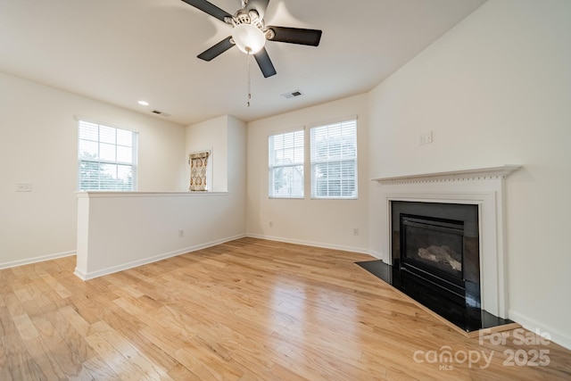 9001 Lanark Ln, Indian Land, SC 29707 - unfurnished living room with light wood-type flooring, a ceiling fan, a glass covered fireplace, baseboards, and recessed lighting