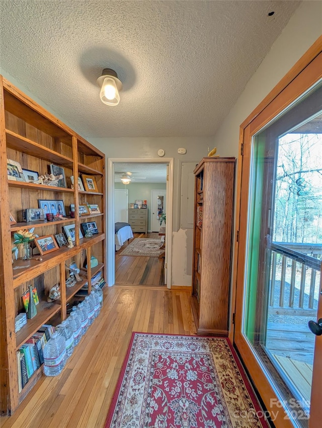 hallway featuring hardwood / wood-style floors and a textured ceiling