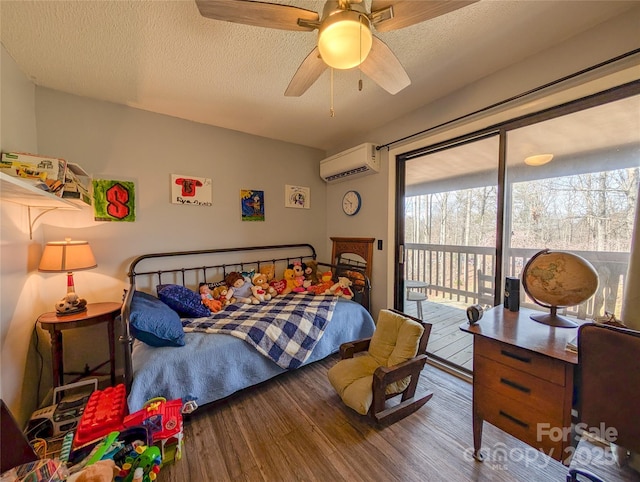 bedroom featuring access to outside, a wall unit AC, multiple windows, and wood finished floors