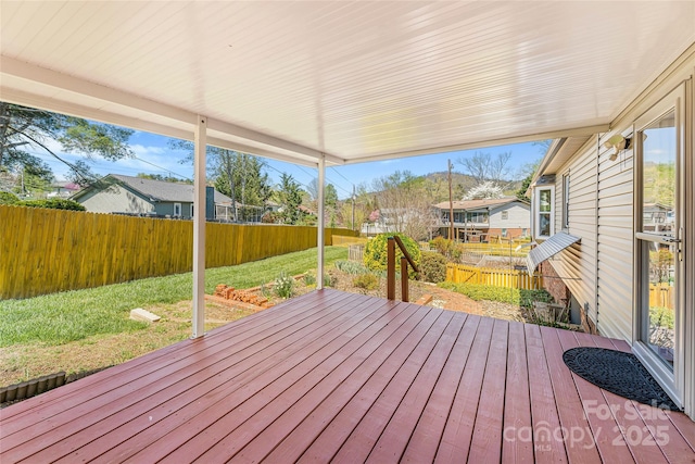 wooden deck featuring a fenced backyard, a residential view, and a lawn