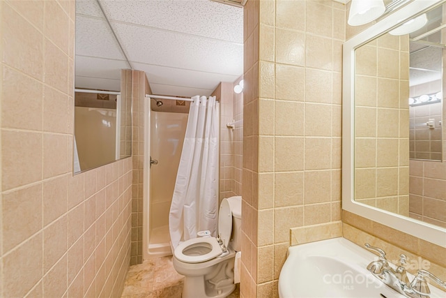 bathroom with a shower with curtain, toilet, a sink, tile walls, and tile patterned floors