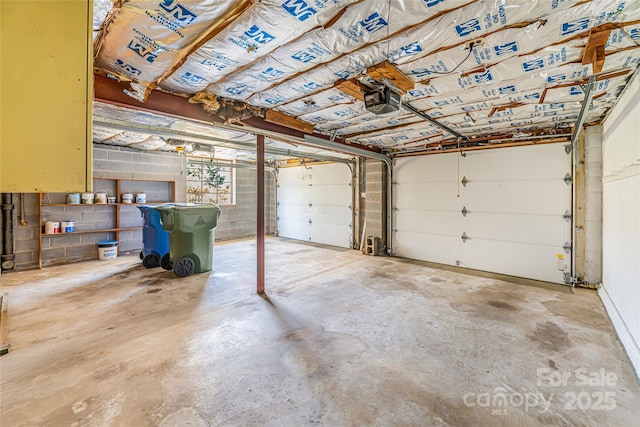 garage with concrete block wall and a garage door opener