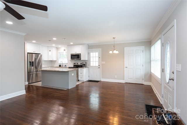 2408 Dora Dr, Charlotte, NC 28215 - kitchen with appliances with stainless steel finishes, a sink, ceiling fan, ornamental molding, and a center island
