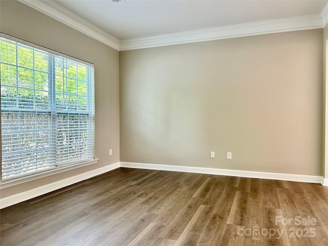 unfurnished room featuring crown molding, baseboards, and wood finished floors
