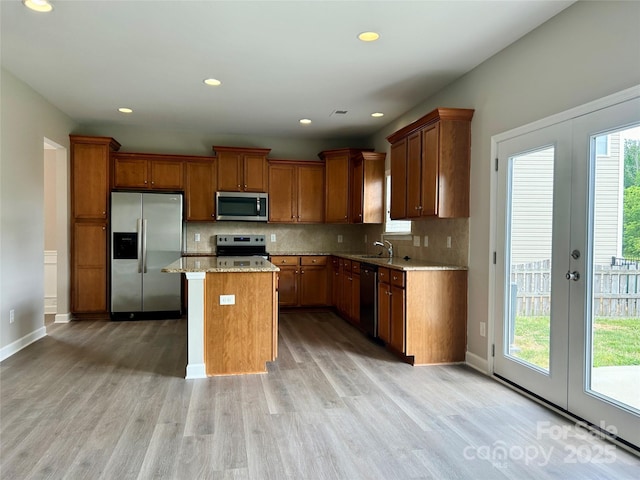 kitchen with french doors, a sink, brown cabinetry, and stainless steel appliances