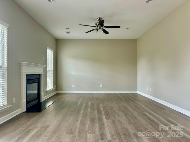 unfurnished living room with ceiling fan, visible vents, wood finished floors, baseboards, and recessed lighting