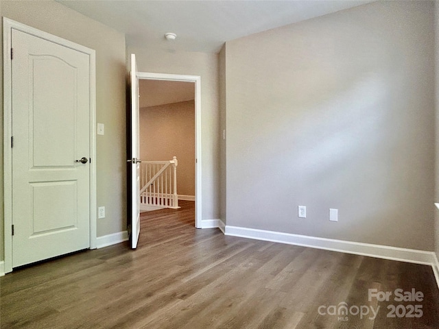 unfurnished bedroom with baseboards and wood finished floors