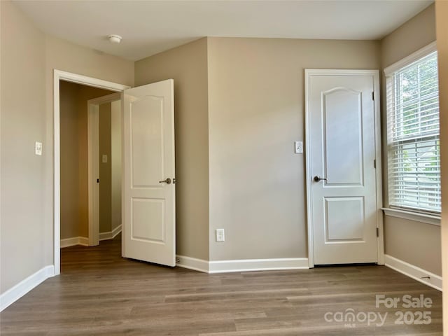 unfurnished bedroom featuring baseboards and wood finished floors