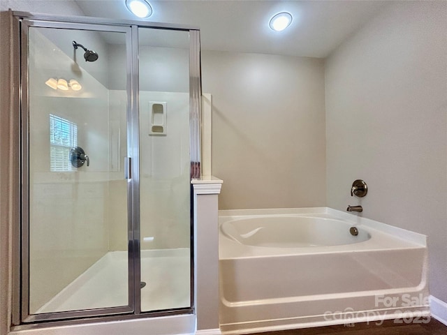 bathroom with a shower stall and a bath