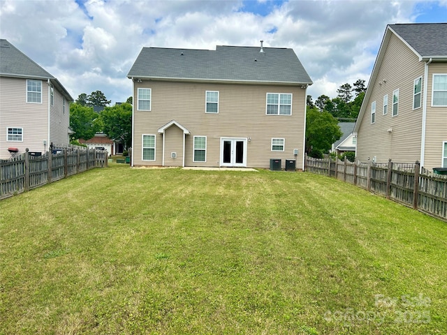 back of house with a yard, central AC unit, a fenced backyard, and french doors