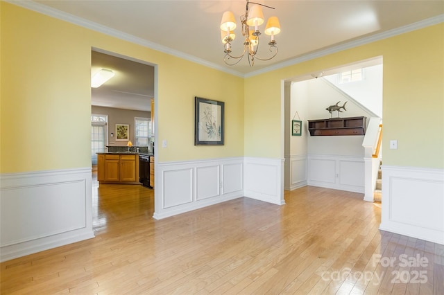 7554 Coastal Way, Huntersville, NC 28078 - unfurnished dining area featuring a wainscoted wall, a chandelier, stairs, ornamental molding, and light wood-style floors