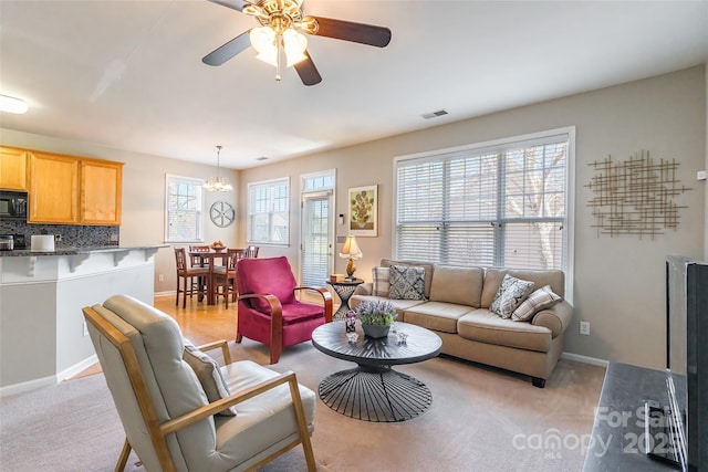7554 Coastal Way, Huntersville, NC 28078 - living area featuring baseboards, visible vents, ceiling fan with notable chandelier, and light carpet