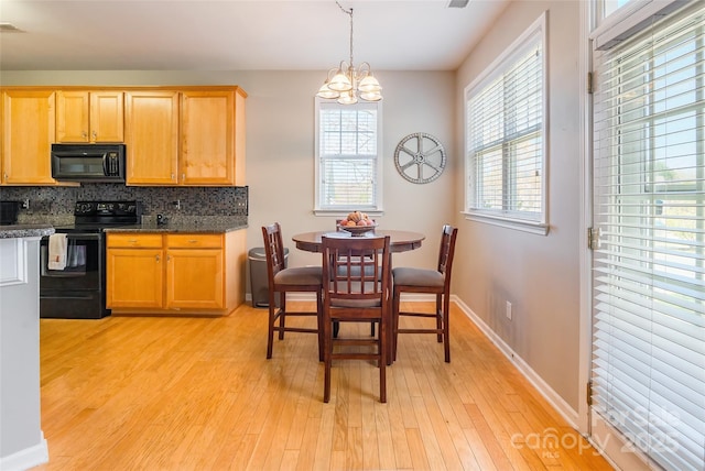 7554 Coastal Way, Huntersville, NC 28078 - kitchen with baseboards, a chandelier, decorative backsplash, light wood finished floors, and black appliances