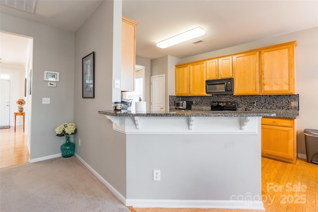 7554 Coastal Way, Huntersville, NC 28078 - kitchen featuring visible vents, black appliances, backsplash, and a kitchen bar