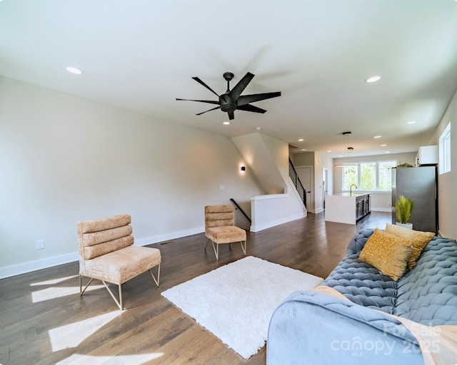 living room with baseboards, ceiling fan, wood finished floors, and recessed lighting