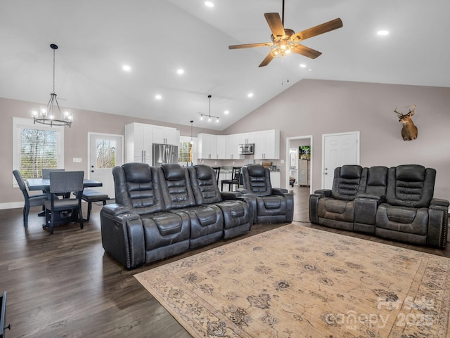 living room featuring high vaulted ceiling, ceiling fan with notable chandelier, recessed lighting, and dark wood-type flooring