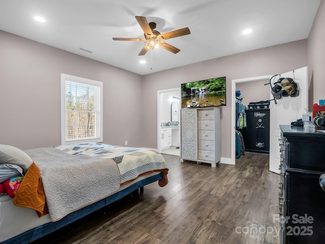 bedroom with a closet, wood finished floors, connected bathroom, a spacious closet, and a ceiling fan