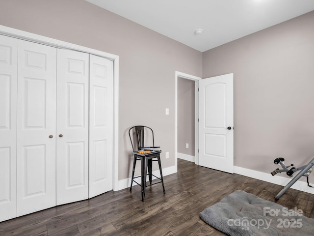 unfurnished room featuring baseboards and dark wood-style flooring