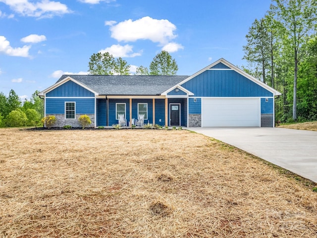 single story home featuring concrete driveway, board and batten siding, stone siding, and a garage