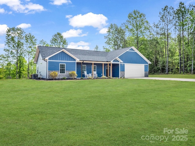 ranch-style home with board and batten siding, driveway, a front yard, an attached garage, and stone siding