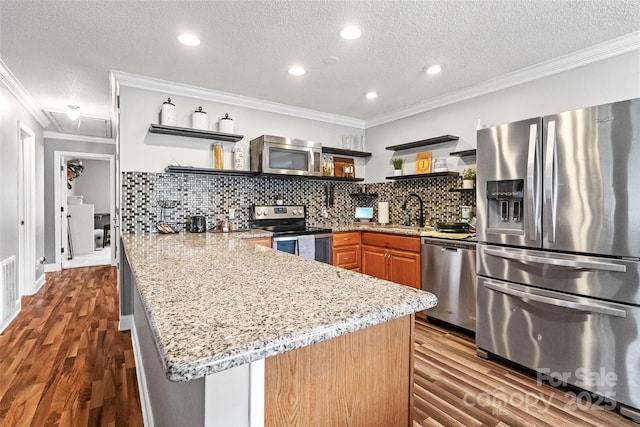 kitchen with open shelves, wood finished floors, a peninsula, stainless steel appliances, and ornamental molding